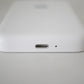 Close-up of a white electronic device with a USB-C port on a light gray background